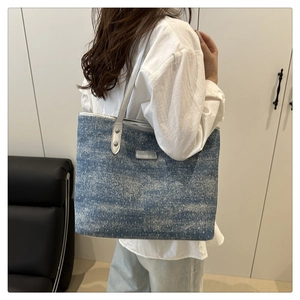 Détail du grand sac cabas en denim pailleté bleu avec poignées métalliques argentées