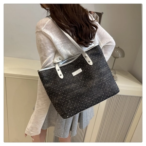 Sac fourre-tout gris à pois blancs avec détails en cuir argenté sur un mannequin