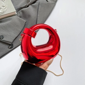 Mini red glossy crescent handbag with sculptural twist design and elegant gold chain strap