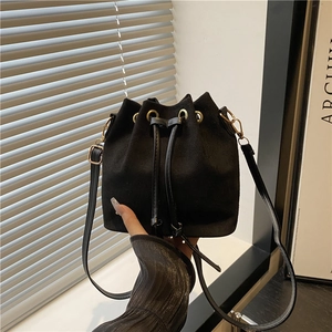 Sac seau noir tendance en daim doux avec des détails dorés élégants et cordons