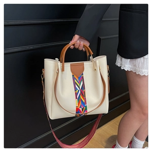 Dettaglio della borsa tote beige con tracolla etnica e manico tondo marrone