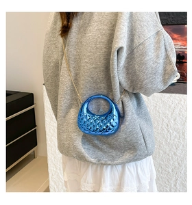 Macro detail of royal blue acrylic mini bag with diamond pattern and gold chain strap