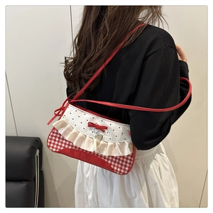 Detail of red gingham plaid crossbody bag with a heart bow and ruffled lace edges