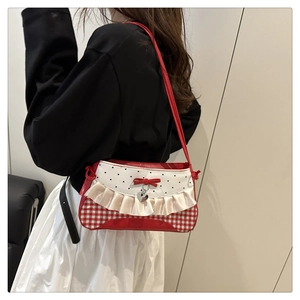 Detail der modischen Schleifen-Schultertasche mit Herzmuster und rotem Karodesign