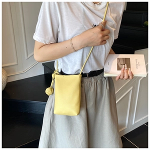 Detail of yellow pebbled leather mini crossbody phone bag with artistic knot strap detail