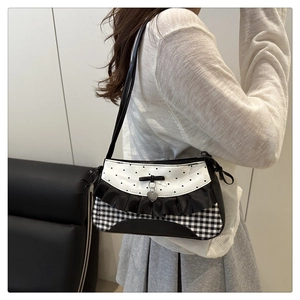 Detail view of contrast bow shoulder bag with heart patterns and ruffle trim