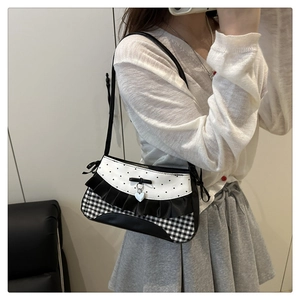 Detail of bow-knot shoulder bag with heart print and gingham ruffles on a model