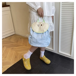 Close-up of light blue backpack with creative pear fruit design and drawstring opening