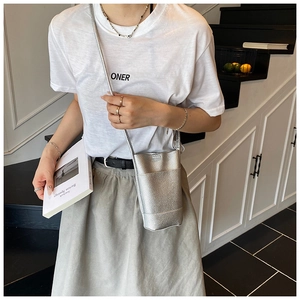 Detail of silver metallic mini crossbody bag with litchi texture and thin shoulder strap