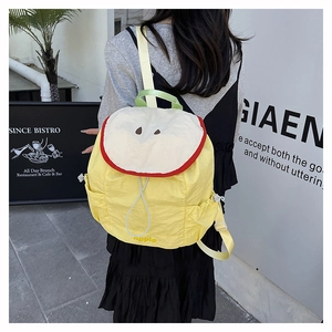 Detail of cute yellow apple-shaped backpack showing embroidery and apple logo text