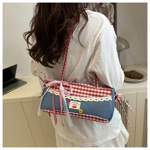 Detail of checkered canvas bag featuring lace edges, red bows and cherry embroidery