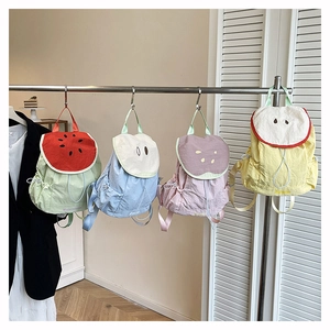 Detailed view of four colorful fruit-themed school backpacks in pastel summer shades