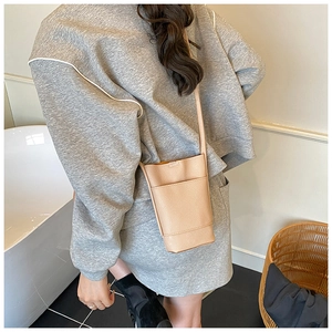Detail of apricot pebbled leather mini crossbody bag shown in a home setting