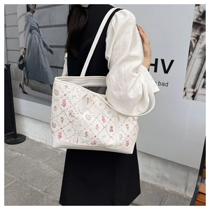 Detail shot of a large white tote bag with cute pink bear patterns on a female model