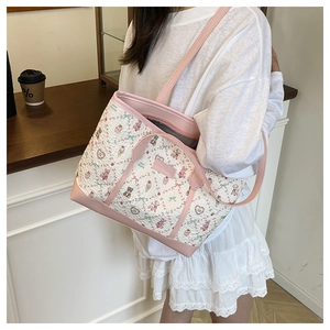 Detail of a pink quilted tote bag with cute bear and rabbit prints shown on shoulder