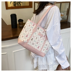 Detail view of pink and white cartoon tote bag featuring bear prints on a shoulder strap