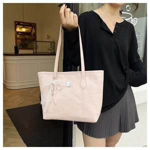 Détail du sac cabas en cuir PU rose avec gaufrage cœur et breloque perle et nœud