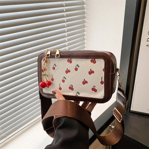 Fashionable brown and white crossbody bag with cherry prints and a cute cherry pendant