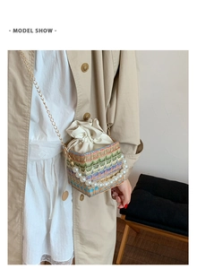 Detail showing the colorful woven texture, large pearl handle, and gold chain of the bag