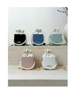 Detailed row of five pearl handle bucket bags in velvet, denim, and textured fabric styles