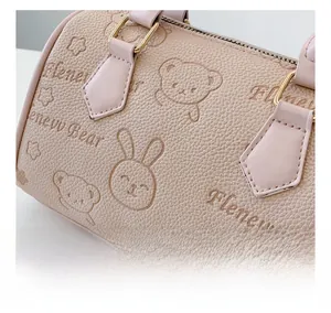 Close-up of cute bear and rabbit embossing on pink lychee grain leather pillow bag