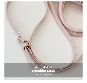 Detailed macro view of adjustable pink shoulder strap with premium golden hardware