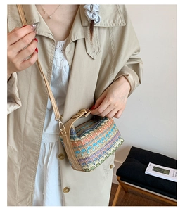 Detail of colorful woven crossbody bag featuring geometric patterns and leather strap
