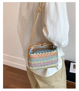 Detail of colorful woven straw bag featuring geometric patterns and a leather strap