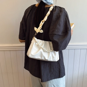 Elegant white ruched cloud bag with pearl chain and satin strap shown on a model