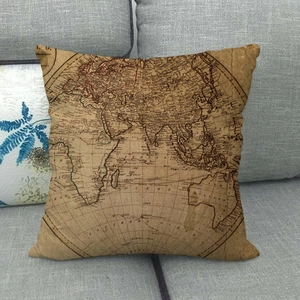 Square vintage world map throw pillow on a grey sofa with rustic linen texture