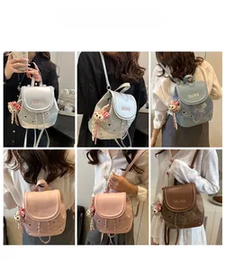 Miniature leather backpack shown in multiple colors with metallic chain and charm