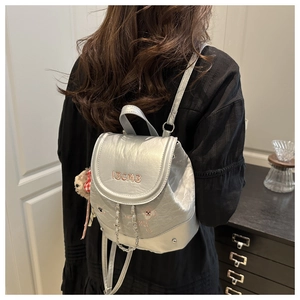 Détail du mini sac à dos argenté avec broderie IBCMB, chaîne fine et motifs de chien
