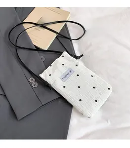 Detail of white pleated fabric bag featuring black floral prints and a Creative Cat label