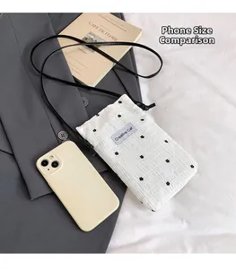 Detailed close-up of a white quilted floral crossbody phone bag with creative cat label