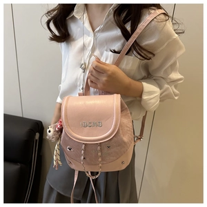 Detailed shot of pink mini backpack with IBCMB embroidery, silver chain, and plush charm
