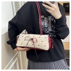 Vue détaillée du sac blanc à pois rouges avec un pendentif en forme de cœur argenté chic
