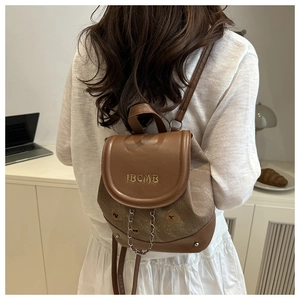 Détail d'un mini sac à dos vintage en toile et cuir avec broderie ours et chaînette