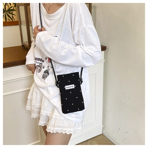 Detail of Creative Cat black floral phone crossbody bag with white flower pattern and logo