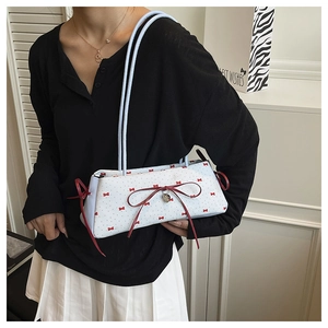 Vue détaillée du sac baguette à fleurs bleu clair avec nœud rouge et pendentif cœur