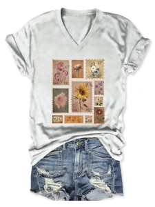 Macro view of white V-neck T-shirt featuring vintage floral stamps and denim shorts