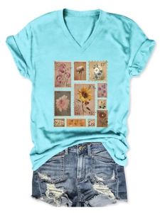 Detailed flat lay of V-neck light blue T-shirt with vintage floral stamp patterns