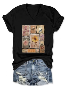 Detail of vintage flower stamp print on black V-neck cotton T-shirt with denim shorts