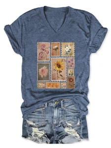 Detailed view of vintage stamp floral print on a navy blue V-neck t-shirt with denim shorts