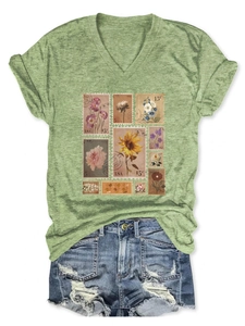 Close-up of vintage floral stamp print on green V-neck T-shirt with denim shorts