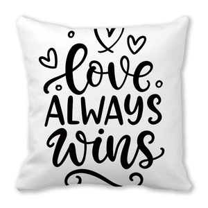 White peach skin cushion cover with black Love Always Wins print and heart icon
