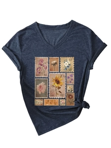 Detail of vintage floral stamp print and rolled sleeves on dark blue V-neck T-shirt