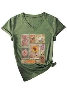 Detail of vintage flower stamp print and knotted hem on a green V-neck T-shirt