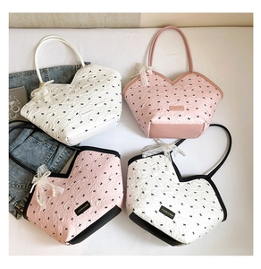 Detail view of quilted tote bags with bow prints and elegant pearl lace charms
