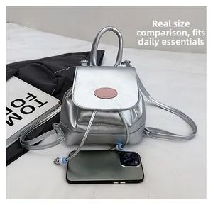 Detailed size comparison of a mini silver bucket backpack with a smartphone