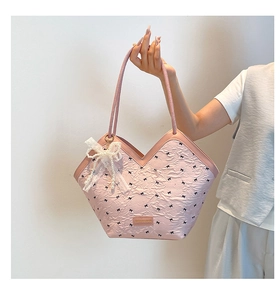 Detail of pink polka dot tote bag featuring ruffled texture and pearl lace bow charm